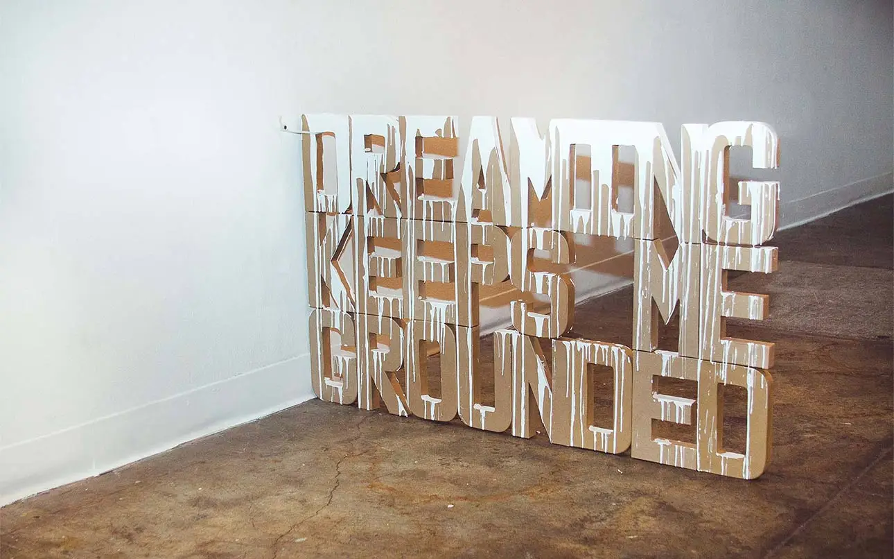 Installation art of 3D typography with the phrase dreaming keeps me grounded.