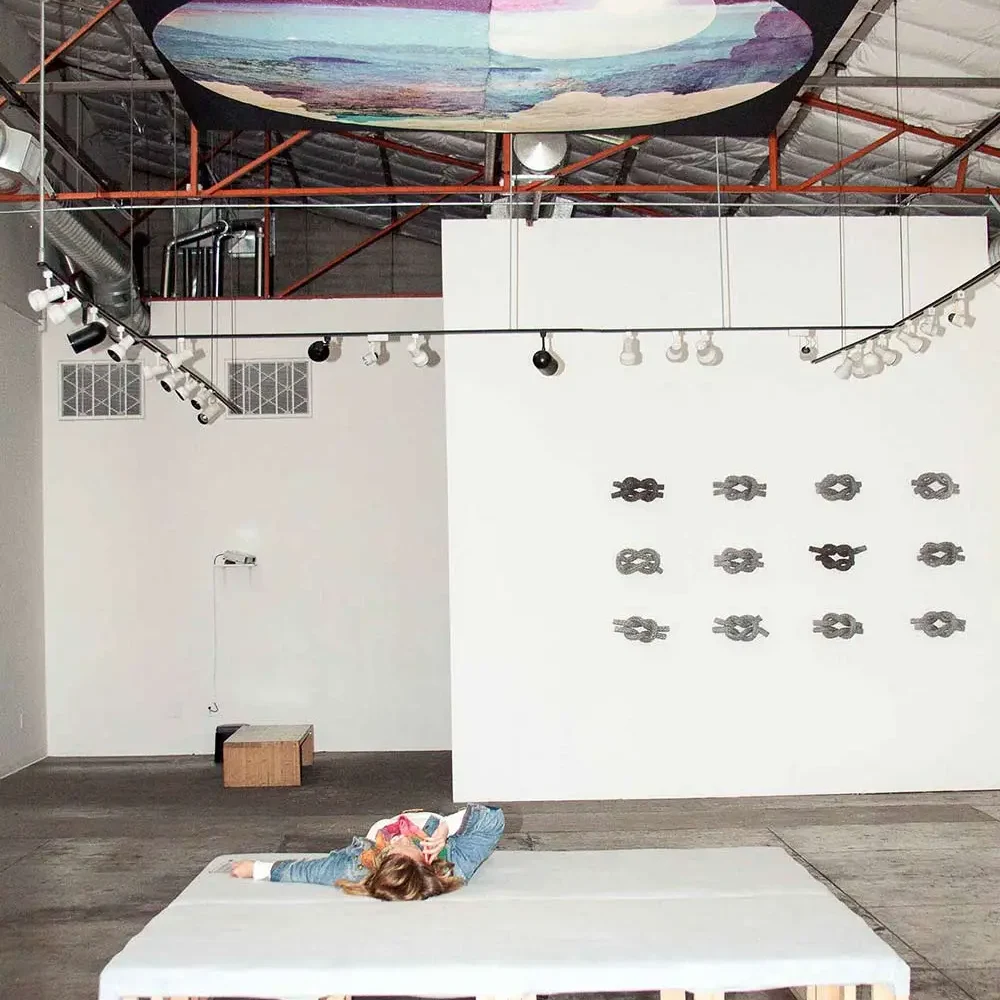 Installation art of a stargazing platform looking up to a custom tapestry created from photography and graphic design imagery.